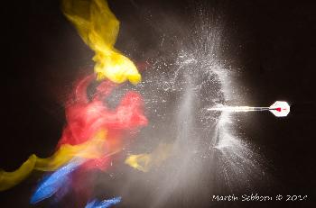 Another excellent timing shot - bursting balloons with a dart